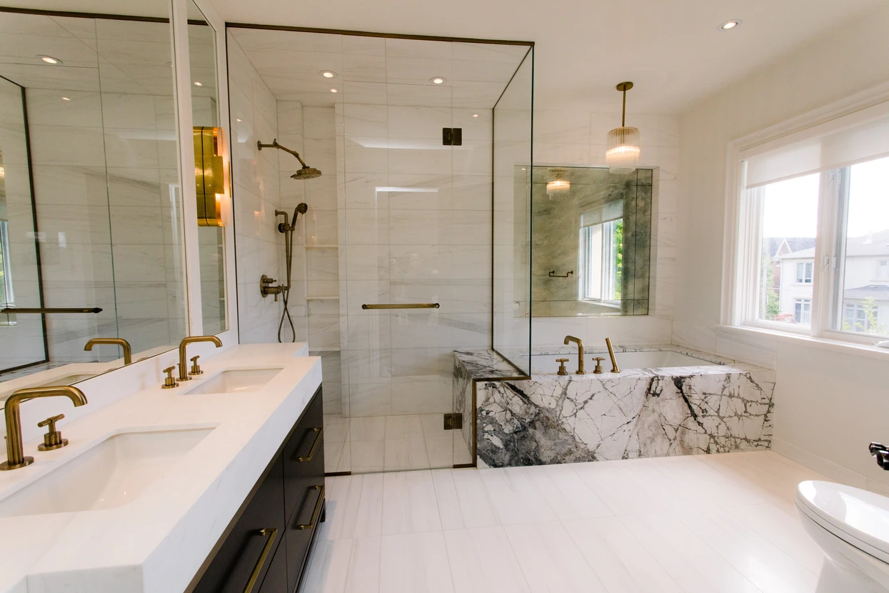 Salle de bain moderne haut de gamme avec douche à l'italienne vitrée, baignoire îlot en marbre veiné, double vasque encastrée