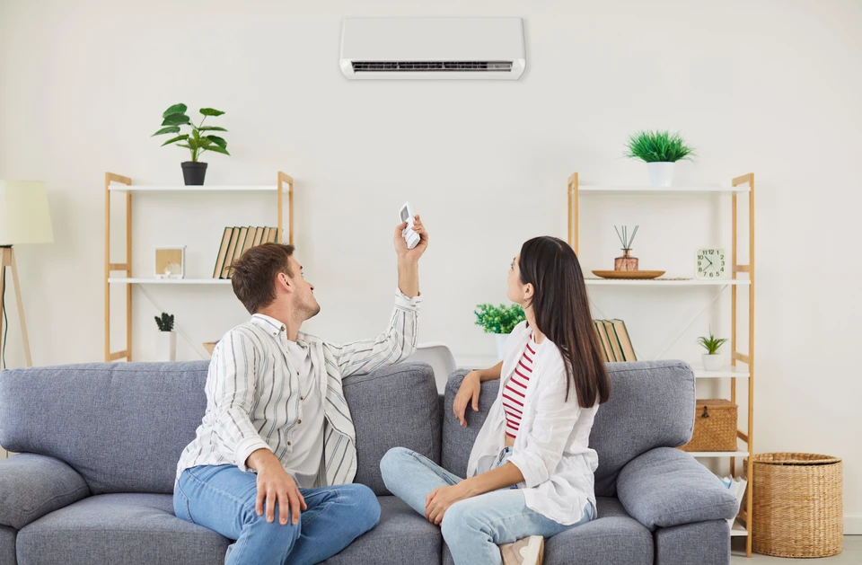 Salon moderne avec climatiseur mural blanc installé sur mur en pierres naturelles grises